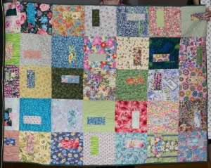 I called this quilt April Showers Bring May Flowers, and the quilting motif is big 1960s-like flower-power flowers. Made with the 10